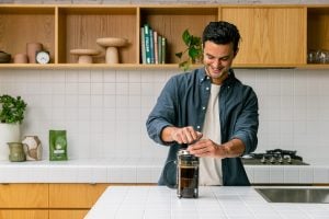 man making plunger coffee
